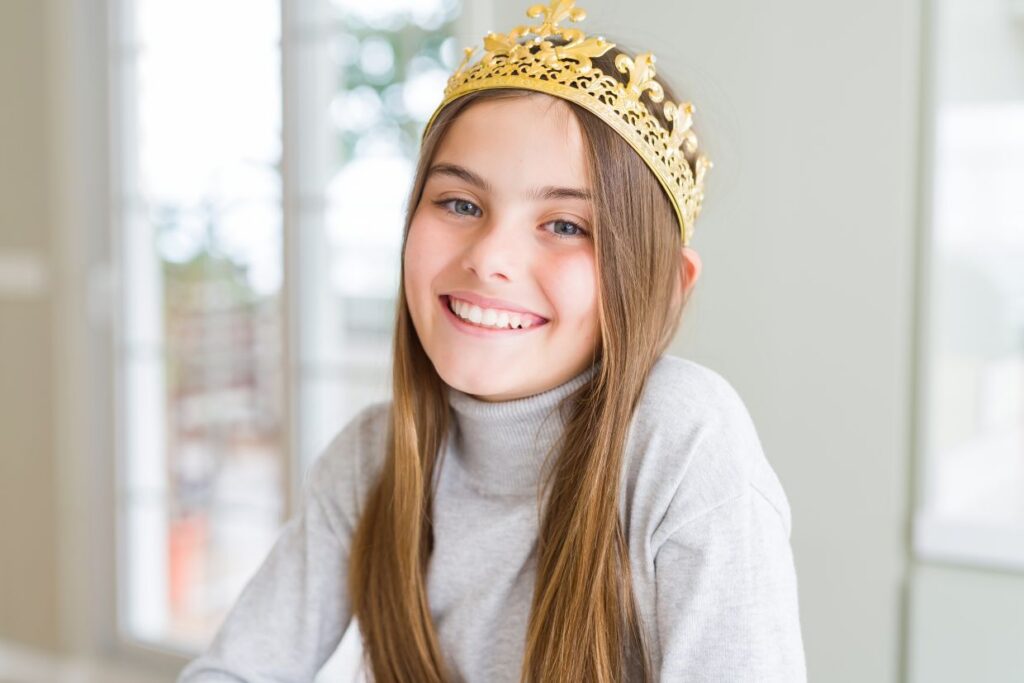 beautiful young girl wearing a golden crown as a princess