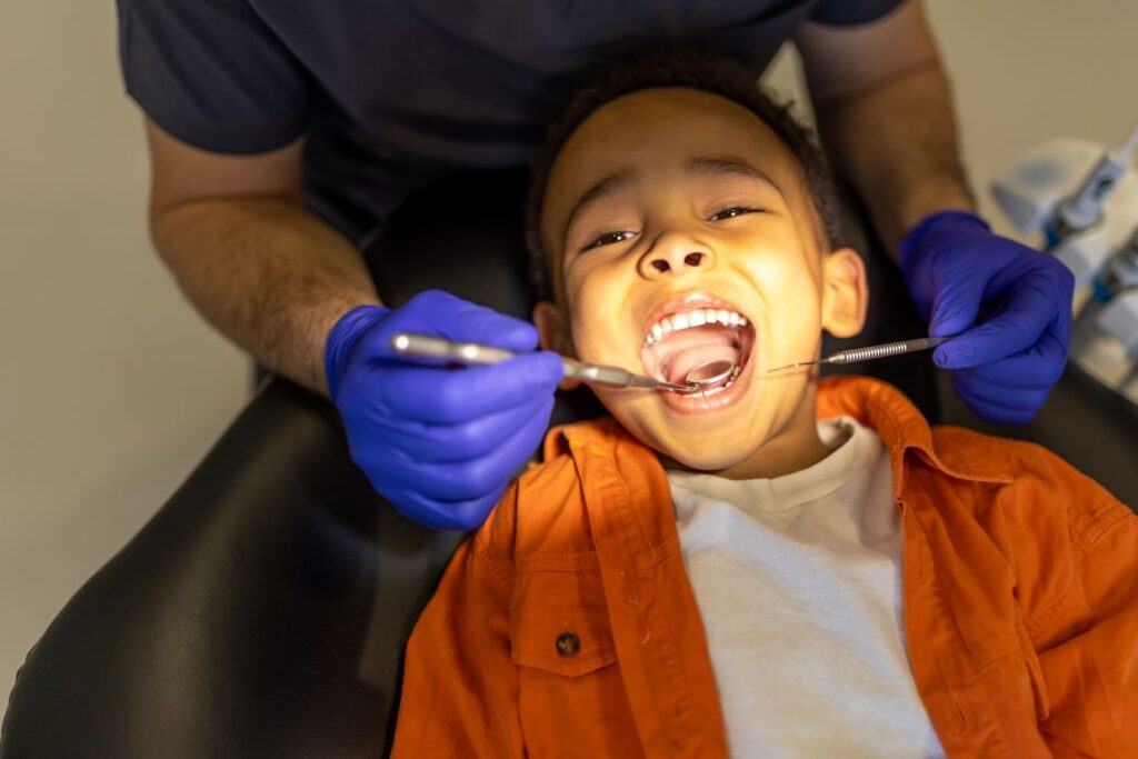 dentist examining oral cavity of a little boy